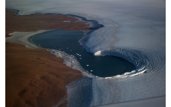 This picture along the NW coast of Greenland captures the island-wide thinning and melting with basal ice (in this case ~55,000 years old) directly on top of the landscape and the gradation along the slope of the ice layers that lead to the surface of the ice sheet today.  The banding, or stratigraphy is marked by major dust depositional periods (surrogates for global drought & warm periods) that are validated by independent water isotope (δ18O, δ2H, and d-excess) measurements (Welker’s lab)  PHOTO: J Sonntag