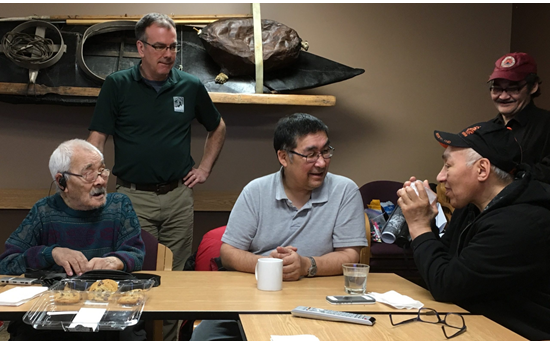 Seated from left are Sikumiut members Gamalie Kilukishak (deceased), Caleb Sangoya and David Angnatsiak (deceased) telling stories about sea ice in Mittimatalik in 2017. Standing from left are Dr. Trevor Bell and Malachi Arreak. Photo from: Memorial University